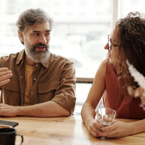 a man and a woman having a discussion in a support group