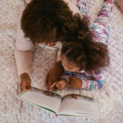 a mom reading her daughter a book in a CASDA emergency shelter